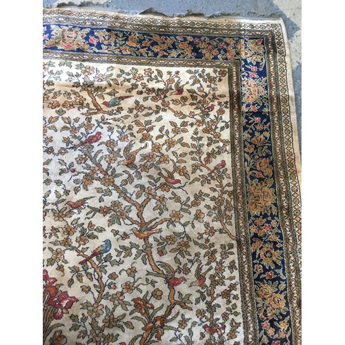 17 - A peach ground Carpet decorated with Tree of Life within blue floral design multiple border, approx ... 