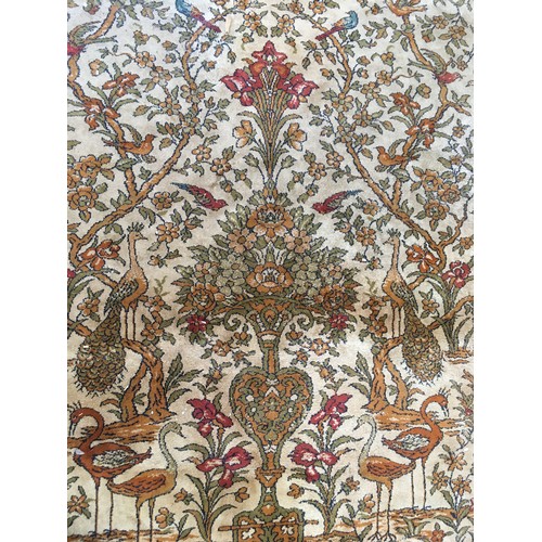 17 - A peach ground Carpet decorated with Tree of Life within blue floral design multiple border, approx ... 