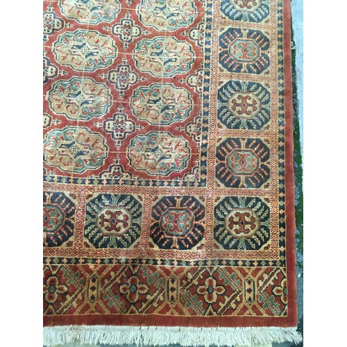 19 - A large terracotta Carpet with five rows of guls within border of deep blue stylised flowers with te... 