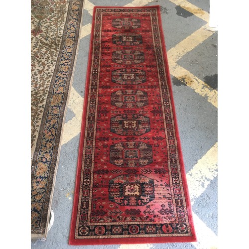 28 - A beige ground Runner decorated with Tree of Life, approx 9ft 10in L x 3ft 2in W and a modern red gr... 