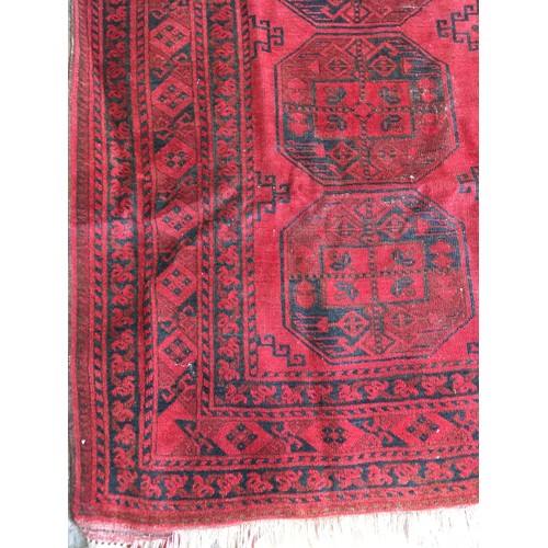 29 - A red ground Afghan Rug, approx 9ft 4in L x 6ft 1in W