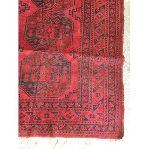 29 - A red ground Afghan Rug, approx 9ft 4in L x 6ft 1in W