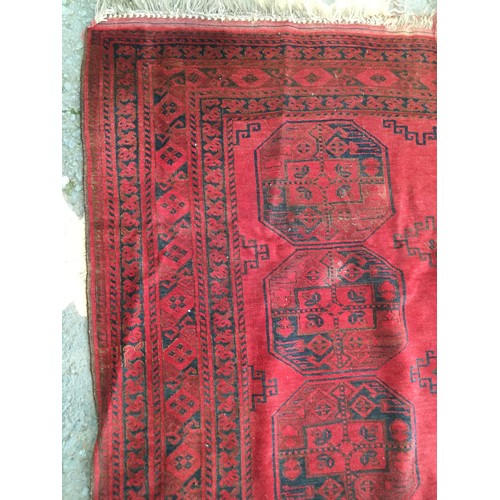 29 - A red ground Afghan Rug, approx 9ft 4in L x 6ft 1in W