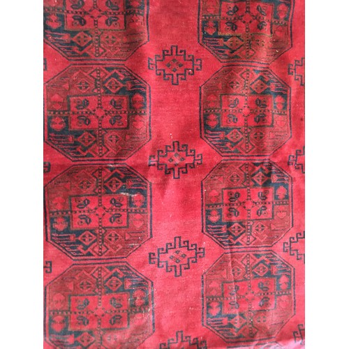 29 - A red ground Afghan Rug, approx 9ft 4in L x 6ft 1in W