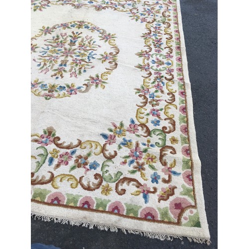 31 - A large cream Carpet with central oval of flowers within floral border, approx 13ft 10in L x 10ft 9i... 