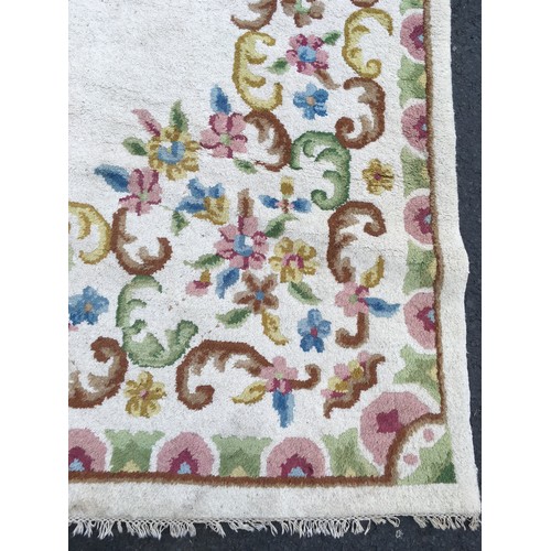 31 - A large cream Carpet with central oval of flowers within floral border, approx 13ft 10in L x 10ft 9i... 