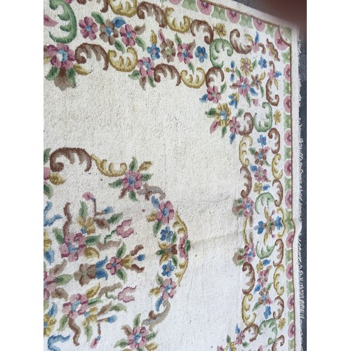 31 - A large cream Carpet with central oval of flowers within floral border, approx 13ft 10in L x 10ft 9i... 