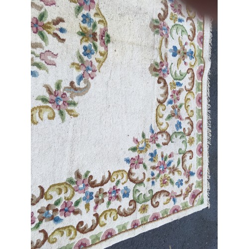 31 - A large cream Carpet with central oval of flowers within floral border, approx 13ft 10in L x 10ft 9i... 