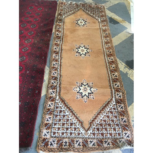 32 - A beige ground Runner, approx 9ft 6in L x 3ft 4in W, a red ground Runner, approx 9ft 8in L x 2ft 9in... 