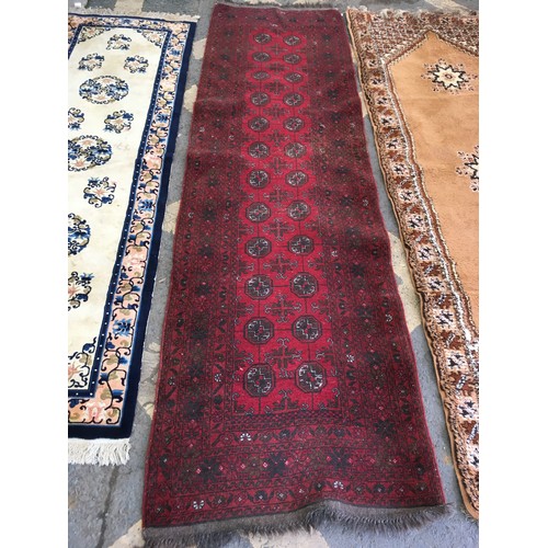 32 - A beige ground Runner, approx 9ft 6in L x 3ft 4in W, a red ground Runner, approx 9ft 8in L x 2ft 9in... 