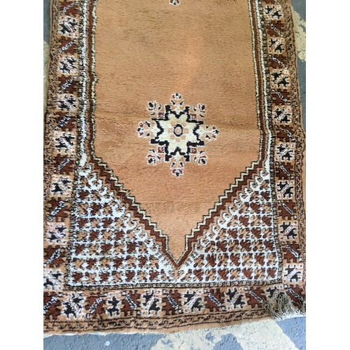 32 - A beige ground Runner, approx 9ft 6in L x 3ft 4in W, a red ground Runner, approx 9ft 8in L x 2ft 9in... 