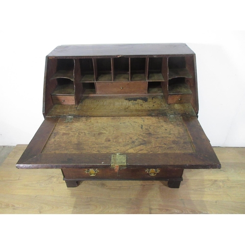 326 - An 18th Century oak Bureau with sloping front enclosing a fitted interior including a well, above tw... 