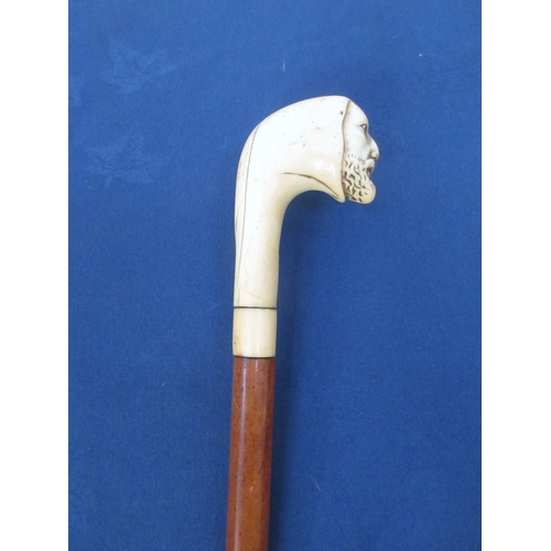 360 - A Malacca Cane with carved mask ivory handle.