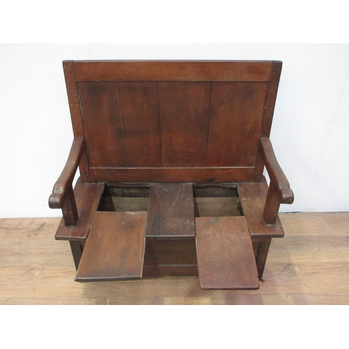 435 - An antique oak and fruitwood Box Settle with single panel back above seat fitted two sliding covers ... 