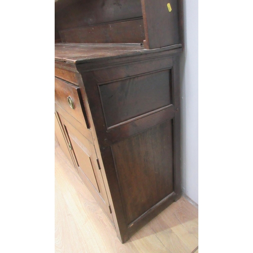 473 - A Georgian oak enclosed Dresser and Rack, the base fitted three drawers above two fielded panel door... 