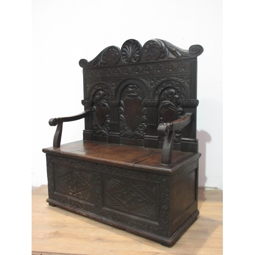 531 - A Victorian carved oak Settle with arcaded back beneath scallop and scroll carved top rail above a b... 