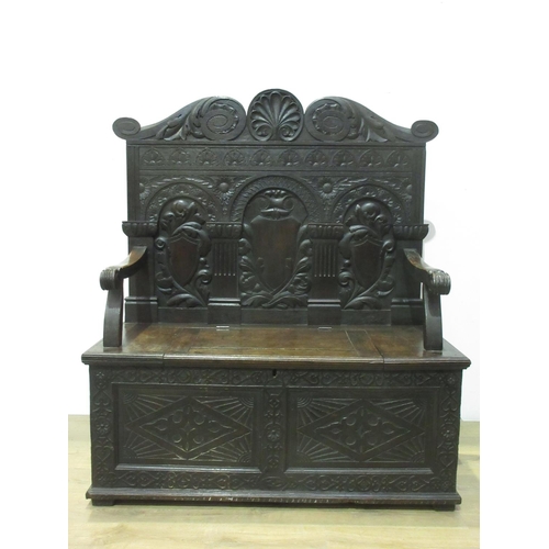 531 - A Victorian carved oak Settle with arcaded back beneath scallop and scroll carved top rail above a b... 