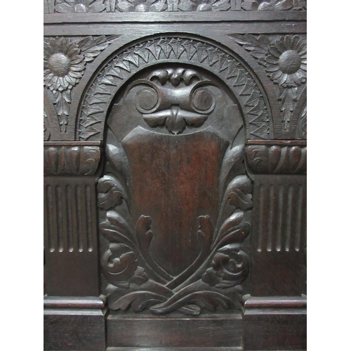 531 - A Victorian carved oak Settle with arcaded back beneath scallop and scroll carved top rail above a b... 