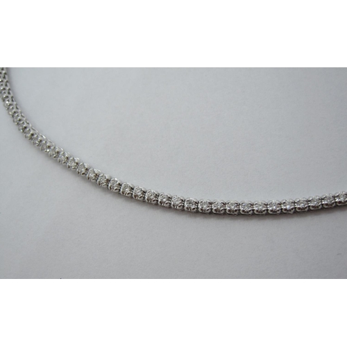 104 - A Diamond Tennis Bracelet, having flexible links each set brilliant-cut stone on hidden clasp in 18c... 