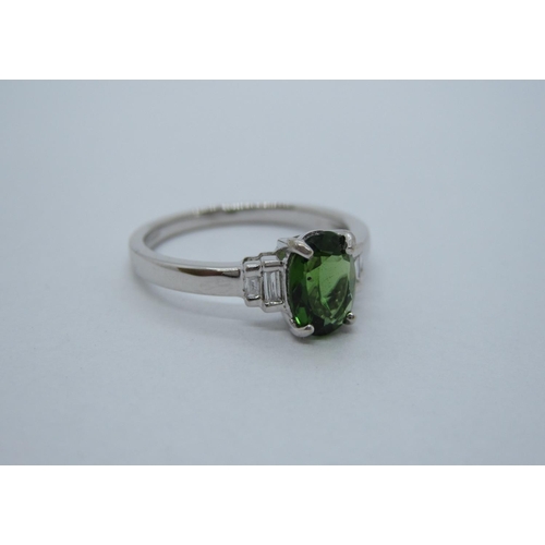 105 - A Green Tourmaline and Diamond Ring, claw-set oval-cut tourmaline between two pairs channel-set diam... 