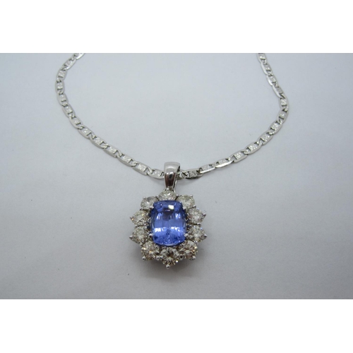 130 - A Tanzanite and Diamond Cluster Pendant, claw-set cushion-cut tanzanite within a frame of ten brilli... 