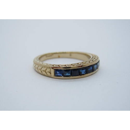 96 - A Sapphire half Eternity Ring, channel-set square baguettes in 9ct gold engraved mounts, ring size M