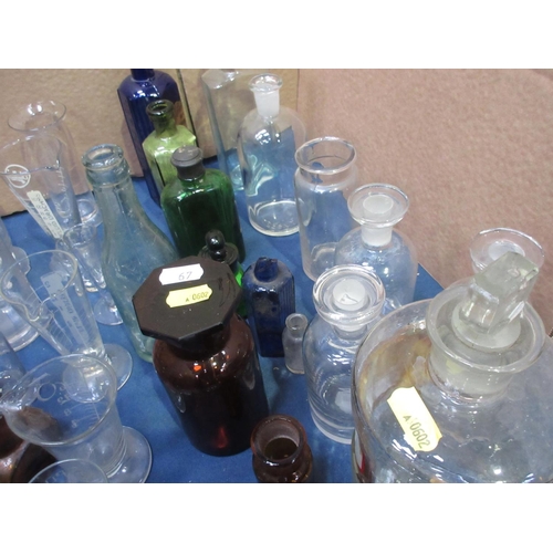 67 - A collection of Apothecary Bottles and Jars, Chemist's Measuring Vessels and other Bottles