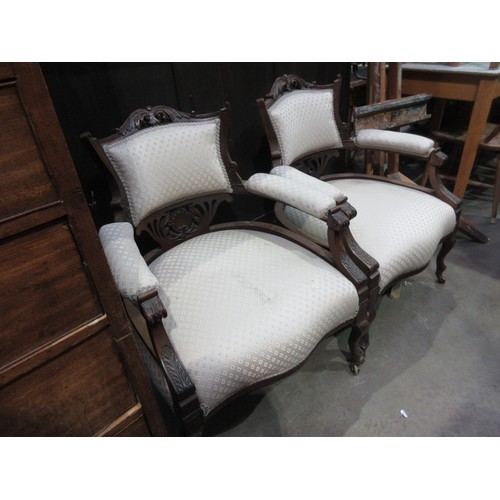 440 - A pair of Victorian walnut framed Elbow Chairs with leafage carved toprail and arms mounted upon cab... 