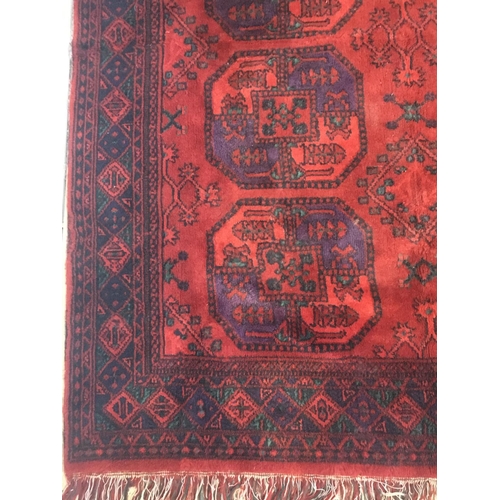 141 - A woollen red ground Rug with two rows of medallions within blue geometric border 5ft 1in L x 4ft 6i... 