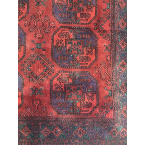 141 - A woollen red ground Rug with two rows of medallions within blue geometric border 5ft 1in L x 4ft 6i... 