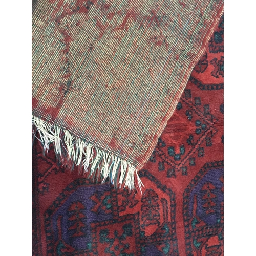 141 - A woollen red ground Rug with two rows of medallions within blue geometric border 5ft 1in L x 4ft 6i... 