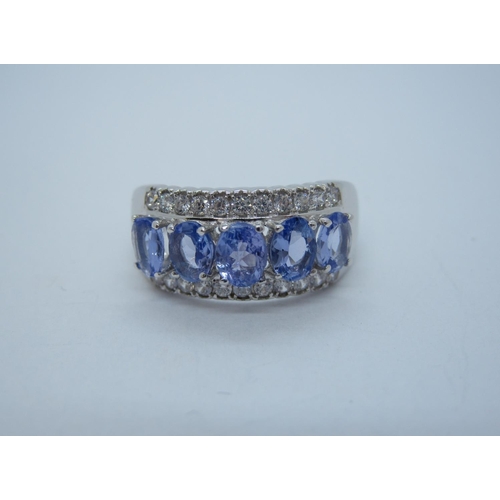 164 - A Tanzanite and CZ Ring claw-set five oval-cut tanzanite between rows of cz, stamped 925, ring size ... 