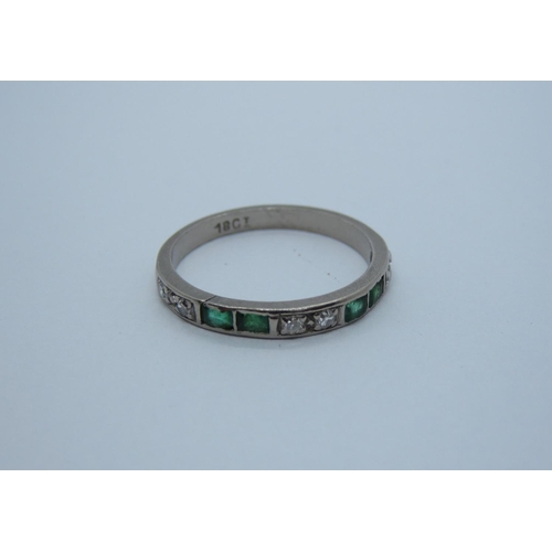 175 - A Diamond and Emerald half Eternity Ring set alternating pairs of eight-cut diamonds and calibre-cut... 