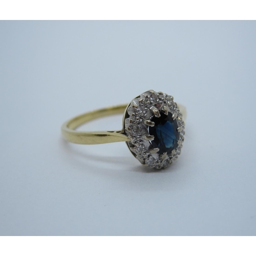 182 - A Sapphire and Diamond Cluster Ring claw-set oval-cut sapphire within frame of illusion-set eight-cu... 