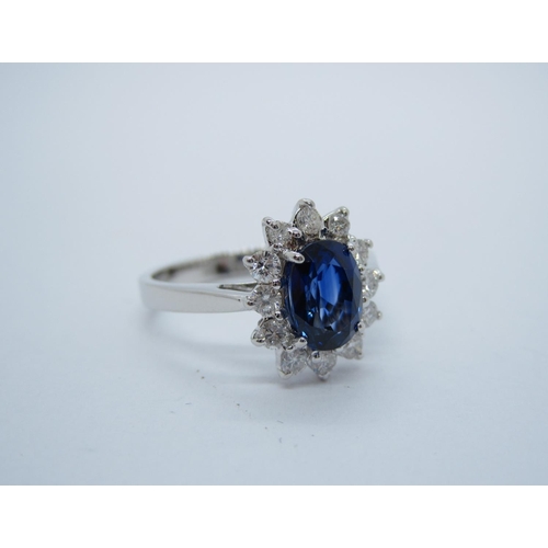 194 - A Sapphire and Diamond Cluster Ring claw-set oval-cut sapphire, 1.40cts, within frame of twelve bril... 