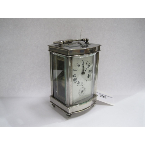 223 - A white metal cased Carriage Clock the white dial with Roman numerals and subsidiary alarm dial, wit... 