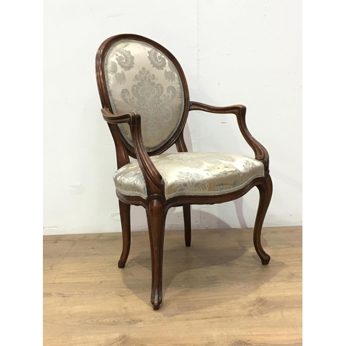 519 - A French walnut framed Elbow Chair with cream silk floral oval back and seat mounted upon cabriole s... 