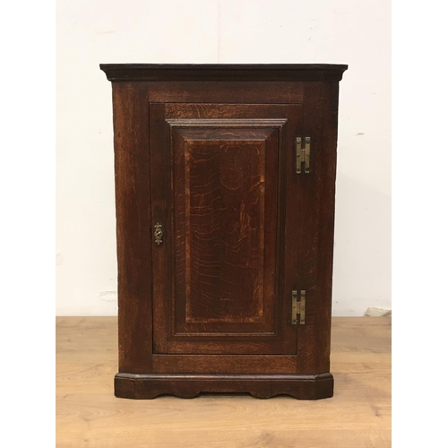 547 - An antique oak hanging Corner Cupboard, the single door enclosing shaped shelves, 3ft 1in H x 2ft W