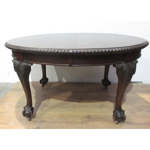 554 - An oval mahogany Dining Table with gadrooned edge and raised on carved cabriole supports and ball an... 