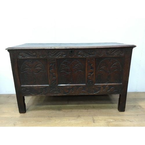 674 - A 17th Century oak Coffer with plank lid above three panel front carved with fritillaries mounted up... 