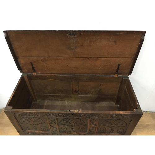 674 - A 17th Century oak Coffer with plank lid above three panel front carved with fritillaries mounted up... 