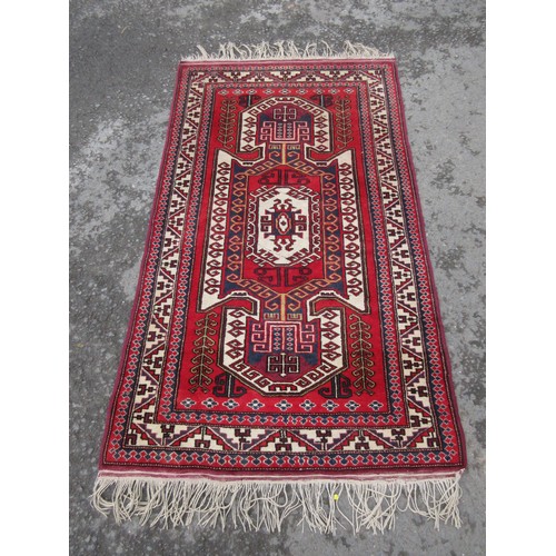 454 - A modern Persian style woollen Rug with central stylised arrowhead on red ground, leaf and wine glas... 