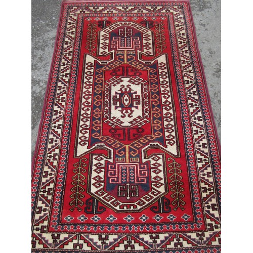 454 - A modern Persian style woollen Rug with central stylised arrowhead on red ground, leaf and wine glas... 