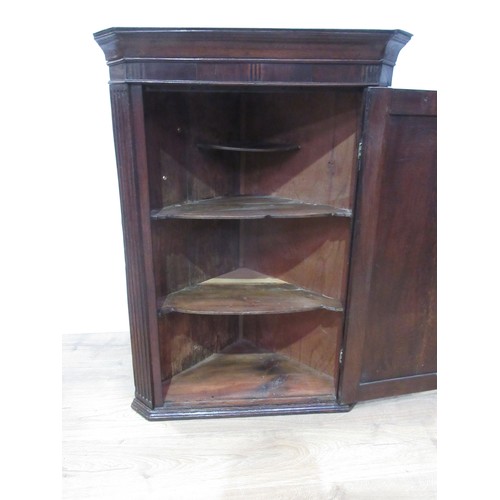 334 - An antique oak Hanging Corner Cupboard with single door enclosing shaped shelves, 3ft 6in H