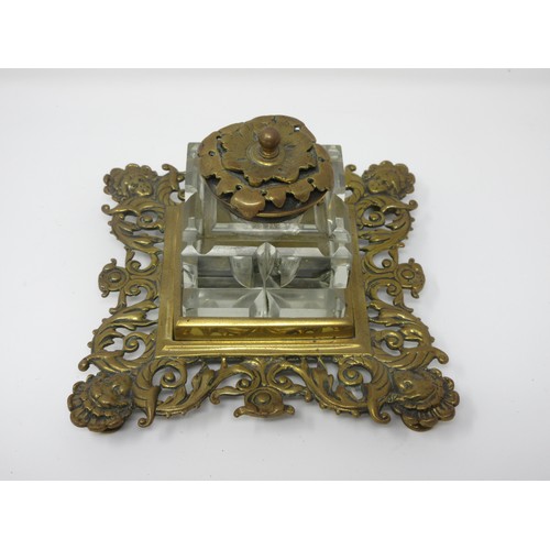 553 - A late 19th Century Aesthetic Movement brass double Inkstand with the brass lidded glass Inkwells on... 