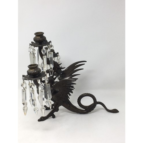 555 - A pair of bronze three-branch Candelabra with cut glass droppers upon cerberus supports, 12in H.