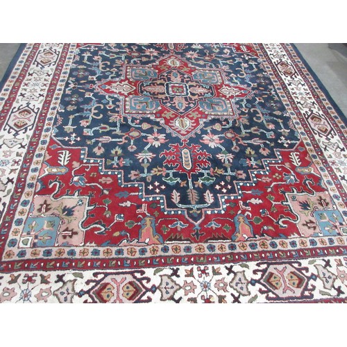 543 - A large woollen blue ground Carpet with red and deep blue central floral motif amongst stylised flor... 