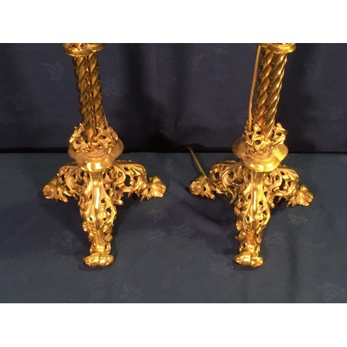 562 - A pair of Gothic influenced gilt brass floor standing Lamps with circular drip tray above three stem... 