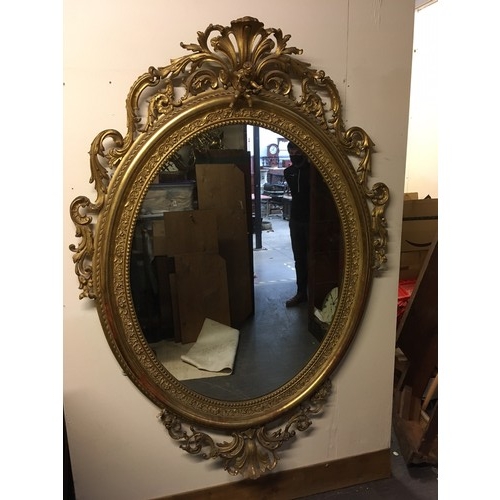 777 - A late 19th Century gilt framed large oval Wall Mirror with cherub and leafage surount and leafage m... 