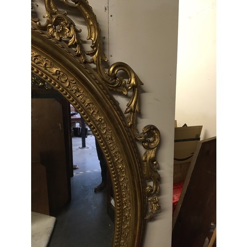 777 - A late 19th Century gilt framed large oval Wall Mirror with cherub and leafage surount and leafage m... 